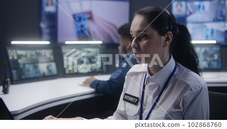 Worker talks by phone in police monitoring center Worker talks by phone in police monitoring center 102868760