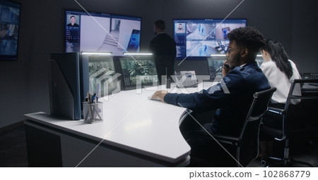 Multi ethnic security operators control cameras 102868779
