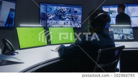 Mixed race officers, operators control security cameras 102868793