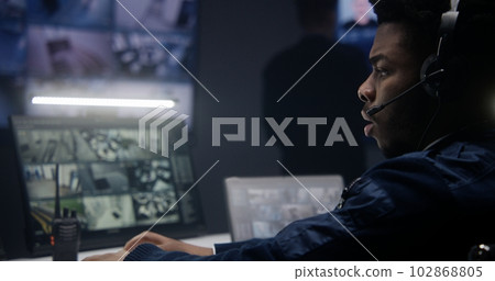 Officer in headset controls security cameras 102868805