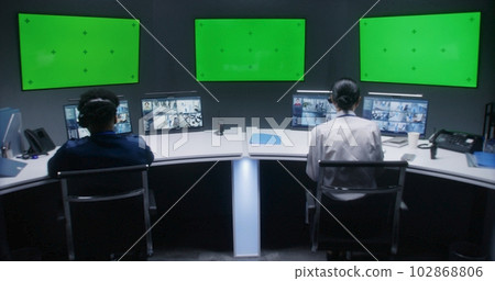 Multi ethnic male and female officers control CCTV cameras 102868806