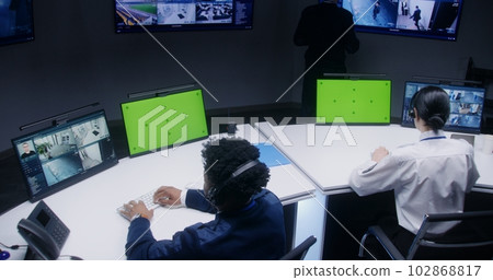 Multi ethnic officers and operators control CCTV cameras 102868817