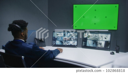African American male officer controls CCTV cameras on computer 102868818