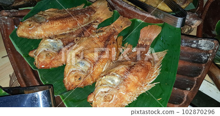 Seafood dish served on the table and plate from above with different kind of dish from fried fish barracuda, snapper, sardines, and also mix of tropical Seafood dish served on the table and plate from above with different kind of dish from fried fish barracuda, snapper, sardines, and also mix of tropical 102870296