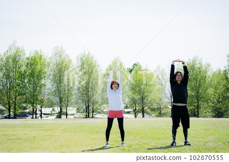 Young couple stretching in the park 102870555