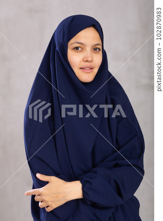 Portrait of young positive woman in khimara posing in studio Portrait of young positive woman in khimara posing in studio 102870983