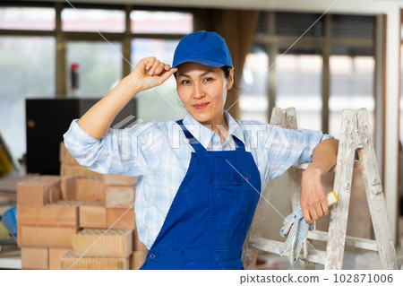 Portrait of contented female foreman of construction team inside cottage under renovation 102871006