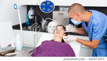 Cosmetologist giving beauty injections to female in aesthetic medicine office 102871053
