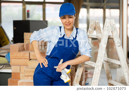 Portrait of contented female foreman of construction team inside cottage under renovation 102871073