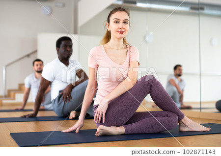 People exercising lord of the fishes asana in gym People exercising lord of the fishes asana in gym 102871143