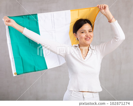 Pretty young female student holding Ireland flag in her hands Pretty young female student holding Ireland flag in her hands 102871274