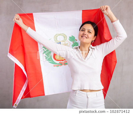 Reliable positive young woman holding a large national flag of Mexico with a confident smile showing teeth 102871412