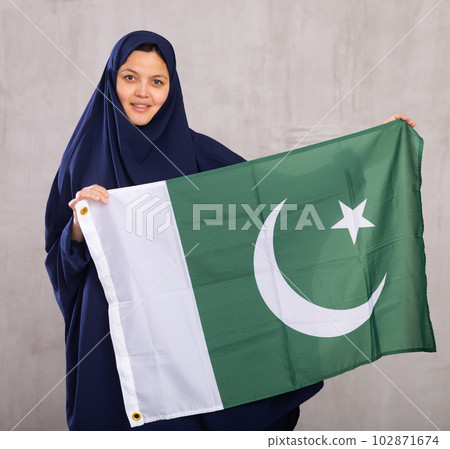 Young woman in hijab posing with Pakistan flag 102871674
