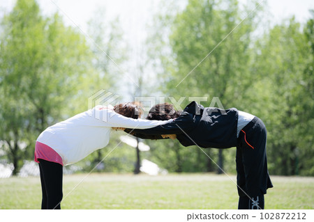 Young couple stretching in the park Young couple stretching in the park 102872212