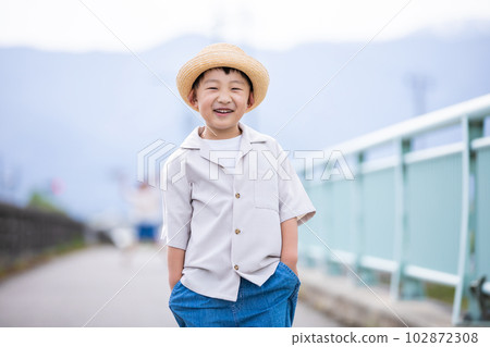A smiling boy wearing a straw hat Smile 102872308