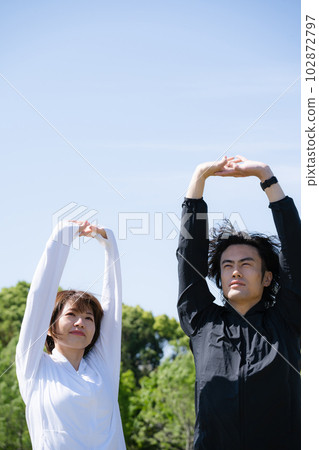 Young couple stretching in the park Young couple stretching in the park 102872797