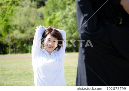 Young couple stretching in the park Young couple stretching in the park 102872799