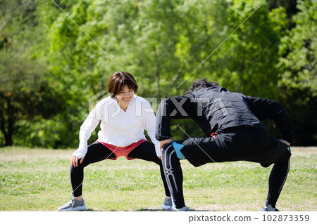 Young couple stretching in the park Young couple stretching in the park 102873359
