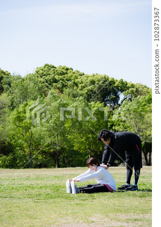 Young couple stretching in the park Young couple stretching in the park 102873367