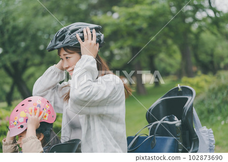mom and daughter wearing bicycle helmets mom and daughter wearing bicycle helmets 102873690