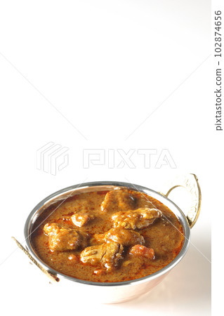 Spicy Indian curry with chicken shot on white background 102874656