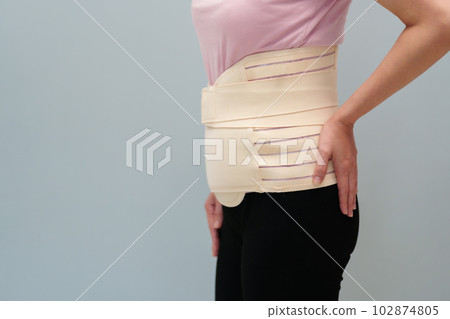 woman wearing lumbar support belts. pregnant and postnatal lumbar brace 102874805