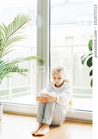Lonely sad girl near the window. Lonely sad girl near the window. 102875513