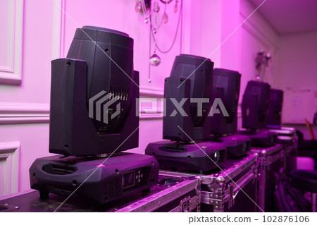 Installation of professional sound, light, video and stage equipment for a concert. Stage lighting equipment is clamped on a truss for lifting. Flight cases with cables. Installation of professional sound, light, video and stage equipment for a concert. Stage lighting equipment is clamped on a truss for lifting. Flight cases with cables. 102876106