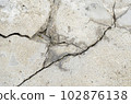 Cracks in the surface of a road or building wall caused by an earthquake 102876138