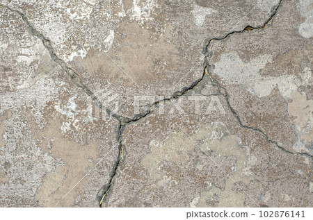 Cracks in the surface of a road or building wall 102876141