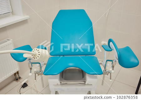 Gynecological cabinet with chair and medical equipment. 102876358