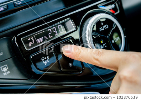 The hand that adjusts the car's air conditioning 102876539