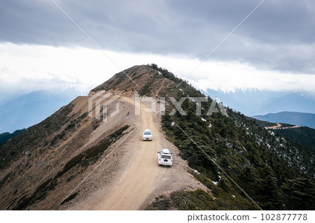 Driving car on high altitude mountain trail, China 102877778