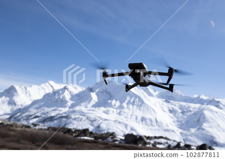 Flying drone in high altitude snow mountains 102877811