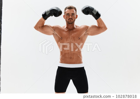 Man athletic bodybuilder poses in boxing gloves with nude torso abs in full-length background, boxing and martial arts. Advertising, sports, active lifestyle, competition, challenge concept. Man athletic bodybuilder poses in boxing gloves with nude torso abs in full-length background, boxing and martial arts. Advertising, sports, active lifestyle, competition, challenge concept. 102878018