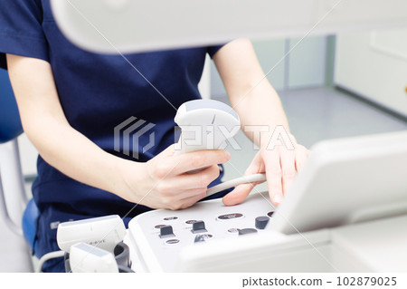 Female doctor sitting in office in a hospital doing ultrasound scanning diagnostic Female doctor sitting in office in a hospital doing ultrasound scanning diagnostic 102879025