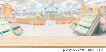 Wood table top with supermarket grocery store blurred defocused background with bokeh light for product display Wood table top with supermarket grocery store blurred defocused background with bokeh light for product display 102880331