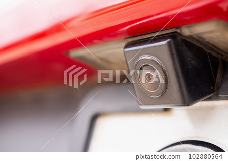 Red car rear view camera close up for parking assistance Red car rear view camera close up for parking assistance 102880564