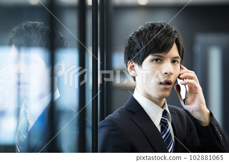Young businessman on the phone in the office Young businessman on the phone in the office 102881065