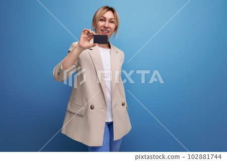 smart european young woman in jacket holding plastic card mockup on studio background smart european young woman in jacket holding plastic card mockup on studio background 102881744