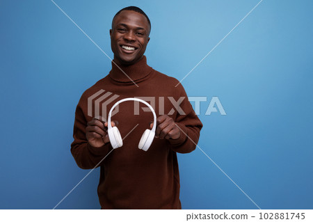 positive young African music maker with white headphones positive young African music maker with white headphones 102881745