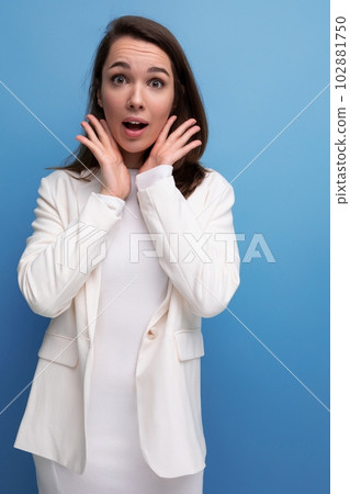 surprised confused pretty brunette young woman in a dress and jacket with a grimace 102881750