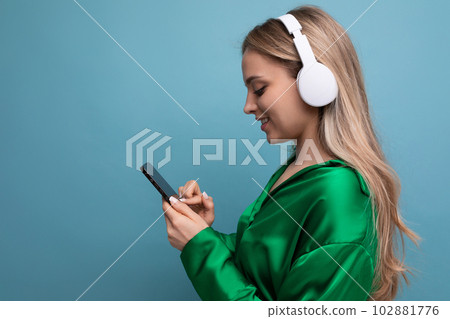 Profile photo of a cute attractive blond young adult woman in headphones on a blue background with Profile photo of a cute attractive blond young adult woman in headphones on a blue background with 102881776