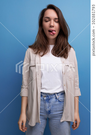 cheerful 30s brunette woman dressed in a shirt with a grimace 102881793