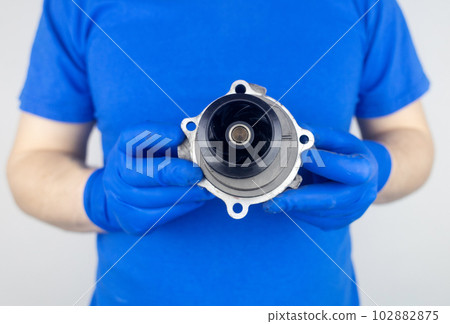 Timing belt cracked. Replacing a failed engine transmission belt. Cracks in rubber and risk of broken cords. Replacement of equipment according to the regulations. Mechanic in blue gloves 102882875