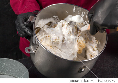 Esterhazy cake. Mixing whipped protein with ground nuts 102884079