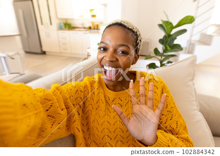 Cheerful Young African Woman Holding A Pillow And Sitting On The