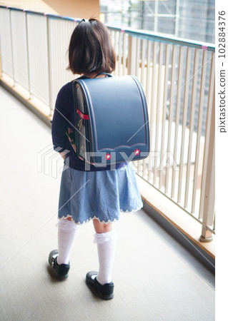 小學三年級結業典禮。背著書包的女孩背影。海軍藍花朵刺繡 小學三年級結業典禮。背著書包的女孩背影。海軍藍花朵刺繡 102884376