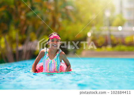 Child in swimming pool on toy ring. Kids swim. Child in swimming pool on toy ring. Kids swim. 102884411