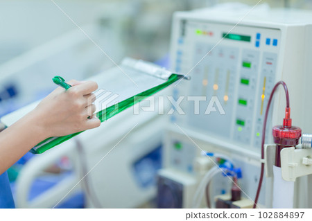 The specialist are checking continuous renal replacement therapy equipment and injection pump and hemodialysis machine. The specialist are checking continuous renal replacement therapy equipment and injection pump and hemodialysis machine. 102884897